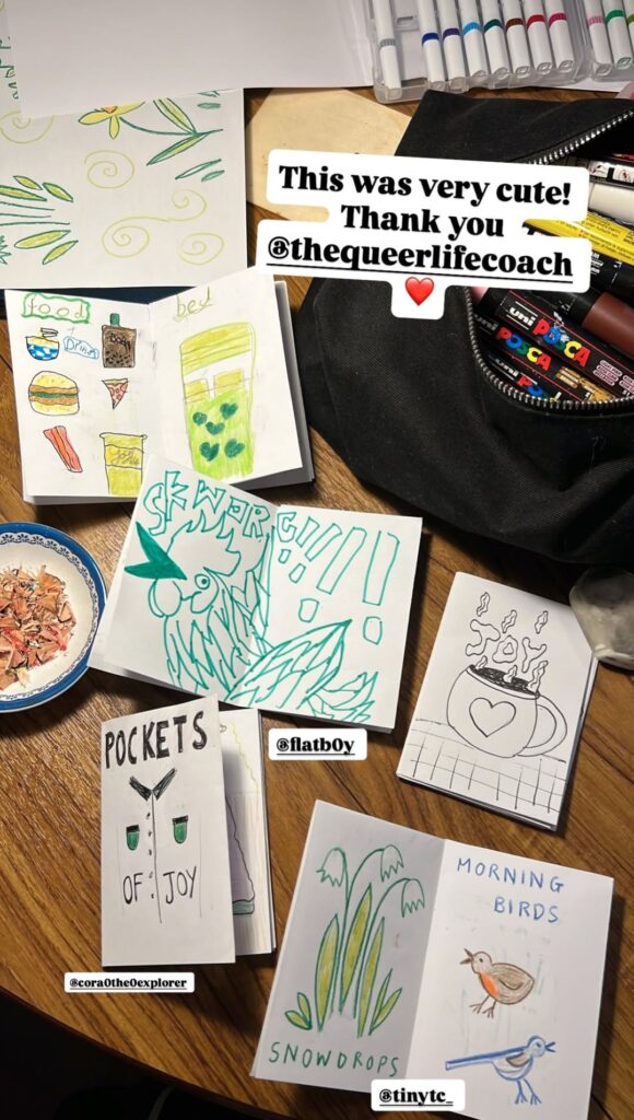 Table full of zines with drawings in them.